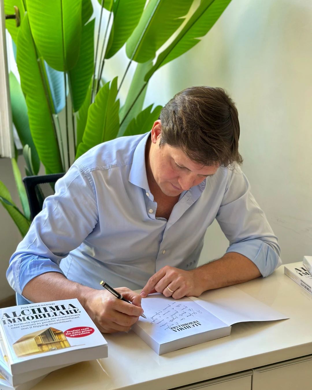 Pier Paolo Ranieri firma alla scrivania accanto al libro